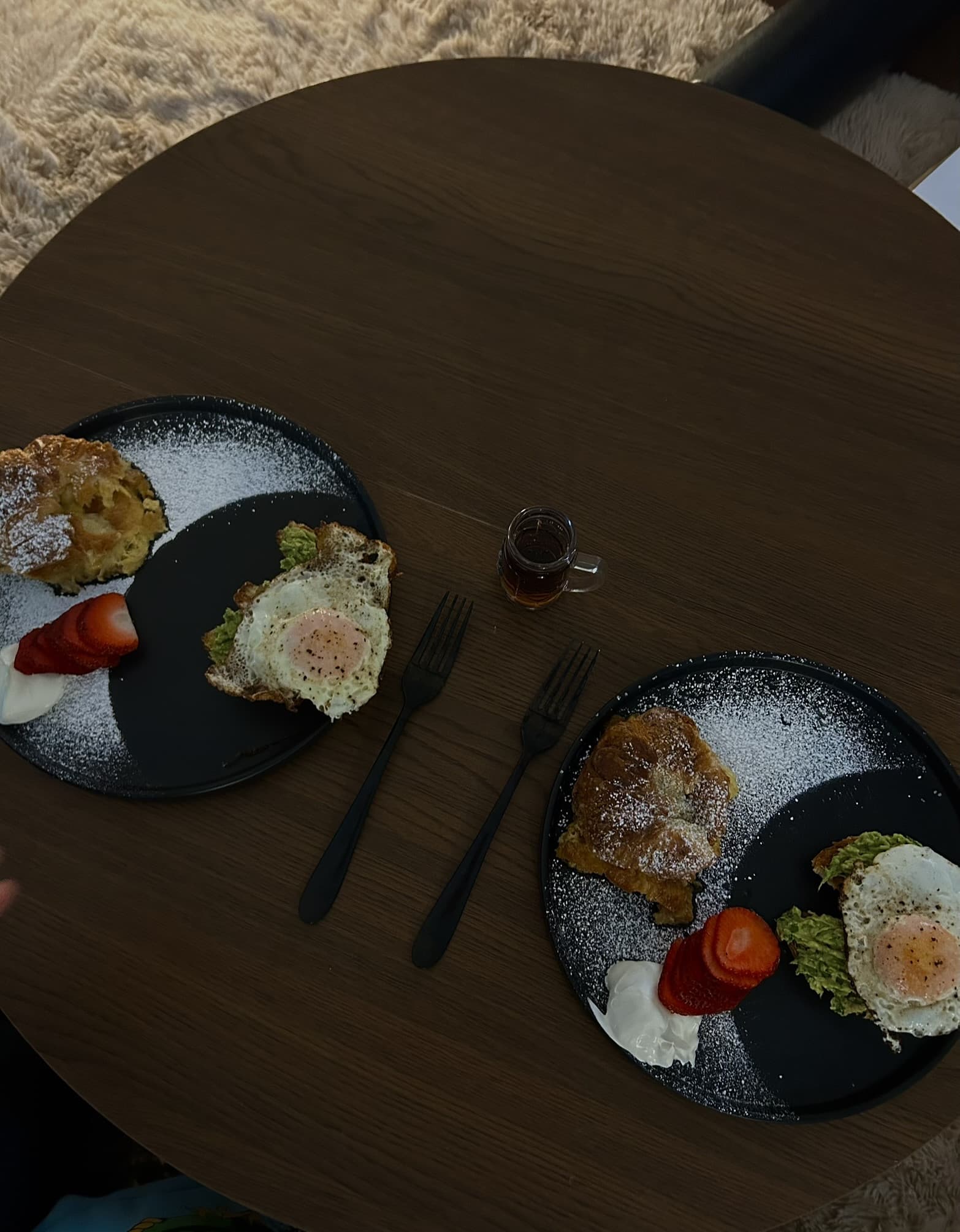 Two plates with French toast croissant bake, avocado croissant toast with a fried egg, strawberries and cream